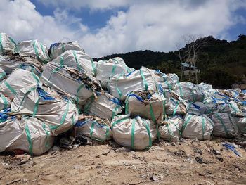 Stack of garbage on land against sky