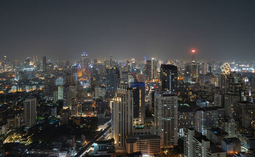 Illuminated cityscape against sky at night