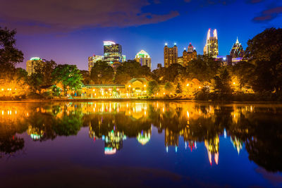 Reflection of trees and buildings in lake at night