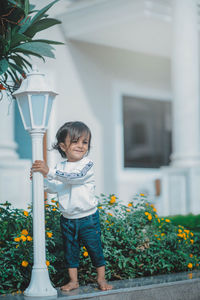 Portrait of boy standing against plants