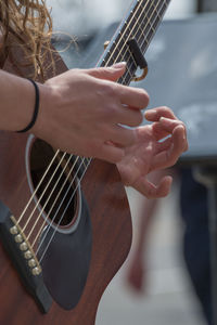 Cropped hands of woman playing guitar