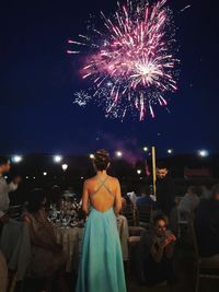 People watching firework display at night