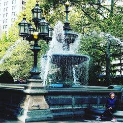 Water fountain against trees in city