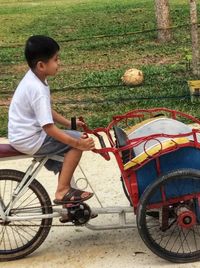 Side view of boy sitting on bicycle