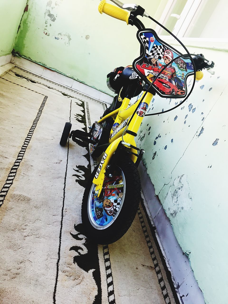 HIGH ANGLE VIEW OF BICYCLE PARKED AGAINST WALL