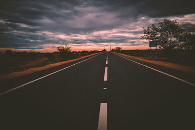 Empty road against sky during sunset