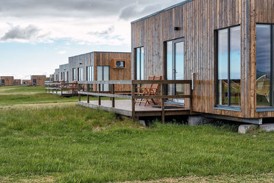 Stylish residential houses cabin with glass panoramic windows and terraces located on green grassy field in countryside of iceland in hvolsvollur