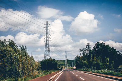 Road by trees against sky