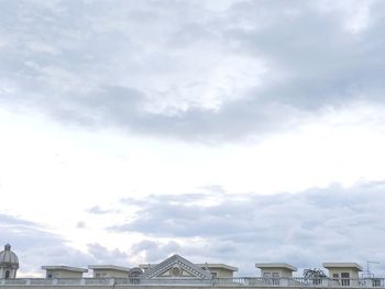 Low angle view of buildings against cloudy sky