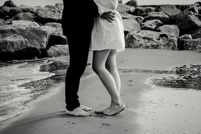 Low section of woman standing on beach