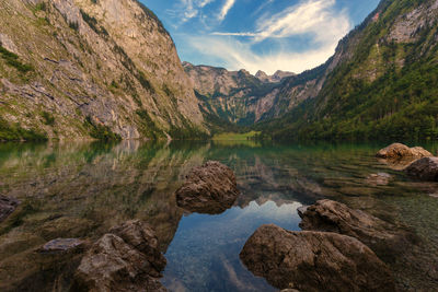 Scenic view of lake by mountains against sky