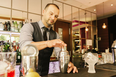 Bartender preparing drink at counter