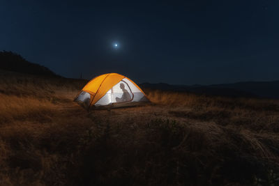 Tent on field against sky at night