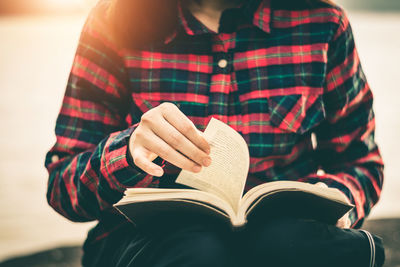 Midsection of woman reading book