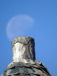 Low angle view of statue against blue sky