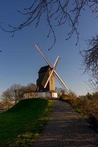 Traditional windmill on field against sky