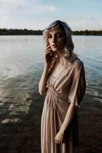 Portrait of young woman standing in lake