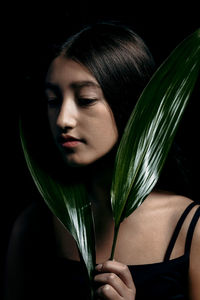 Close-up of young woman holding plant