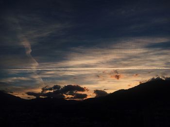 Scenic view of dramatic sky over silhouette landscape