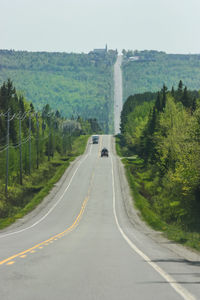 Road amidst trees against sky