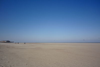 Scenic view of beach against clear blue sky