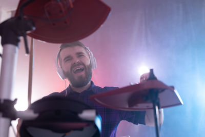 Young man holding camera at music concert