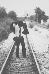 Businessman wearing blazer while standing on railroad track