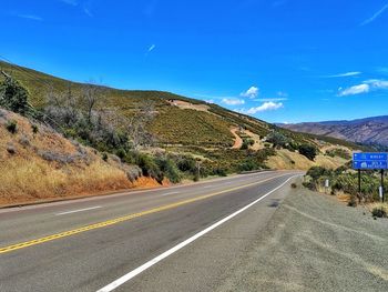 Road leading towards mountains against sky.  on the diagonal. 