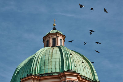 Prague tower cupola with birds flying silhouette pink light