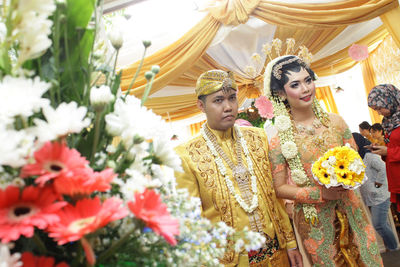 Javanese bride and groom walking on the aisle at wedding ceremony