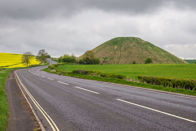 Empty road along countryside landscape