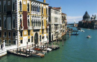 Boats in canal amidst buildings in city