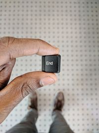 Low section of man holding computer key with end text