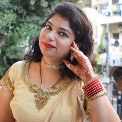 Beautiful woman dressed up as indian tradition with henna mehndi design on her both hands 
