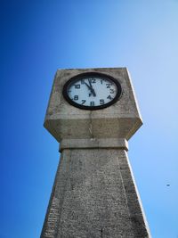 Low angle view of clock tower against clear blue sky