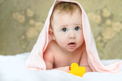 Cute baby girl with towel on head at home