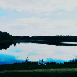 Scenic view of calm lake against cloudy sky