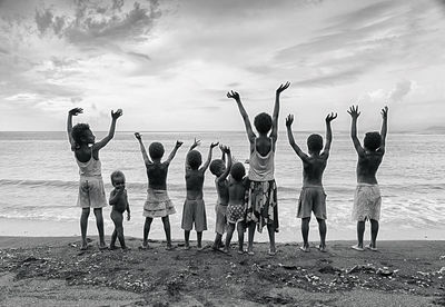 Group of people at beach against sky