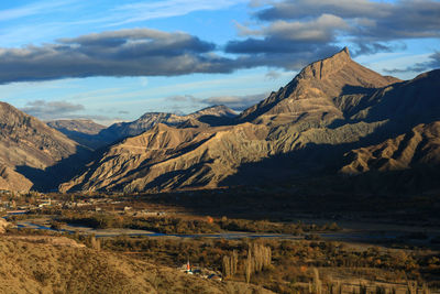 Scenic view of mountain range against cloudy sky