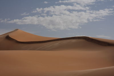 Sand dunes in desert against sky