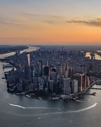 Panoramic view of sea and buildings against sky during sunset