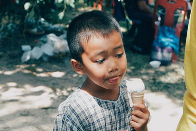 High angle view of cute boy looking away while eating ice cream