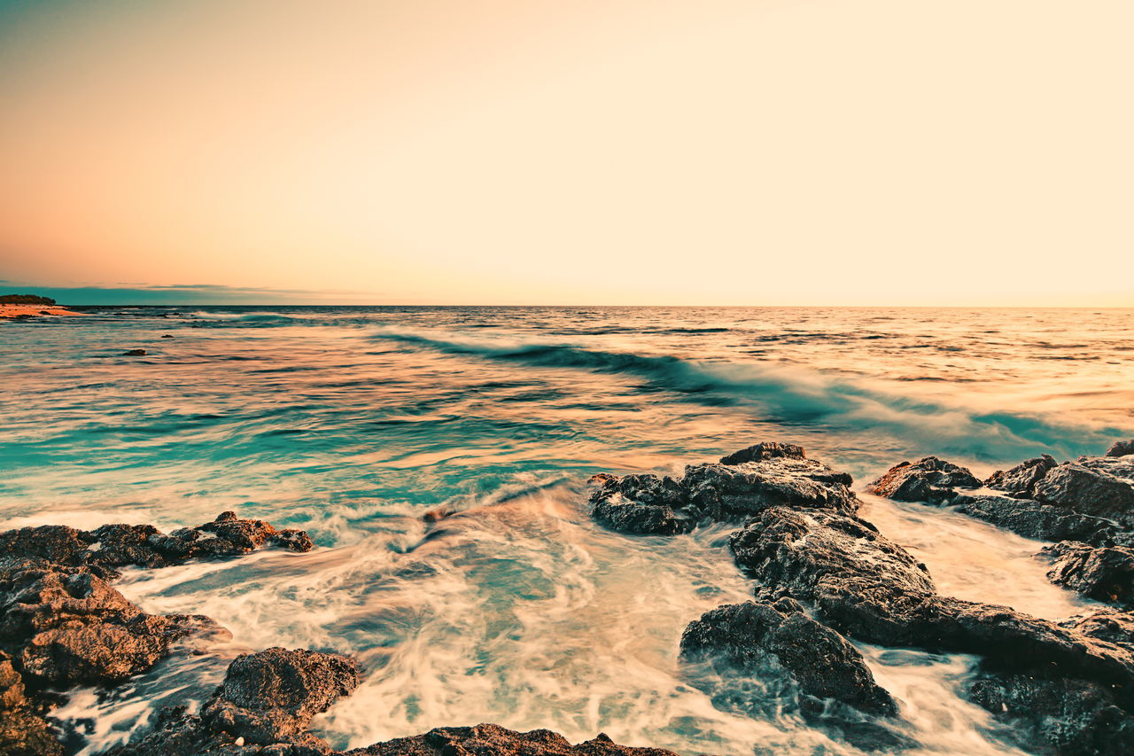 SCENIC VIEW OF BEACH AGAINST SKY DURING SUNSET