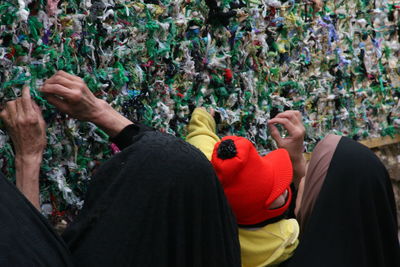 Women tying fabric on wall