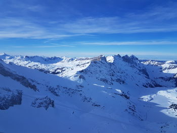 Scenic view of snowcapped mountains against blue sky