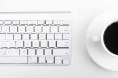 High angle view of coffee cup on laptop