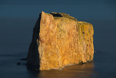 The famous percé rock in the gaspé peninsula seen during a beautiful sunny golden hour afternoon