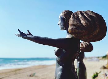 Midsection of man at beach against clear sky