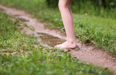 Low section of standing in puddle by grass outdoors