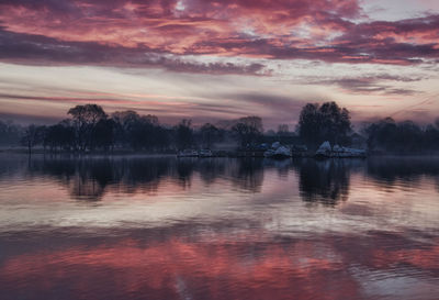 Scenic view of lake against sky at sunset